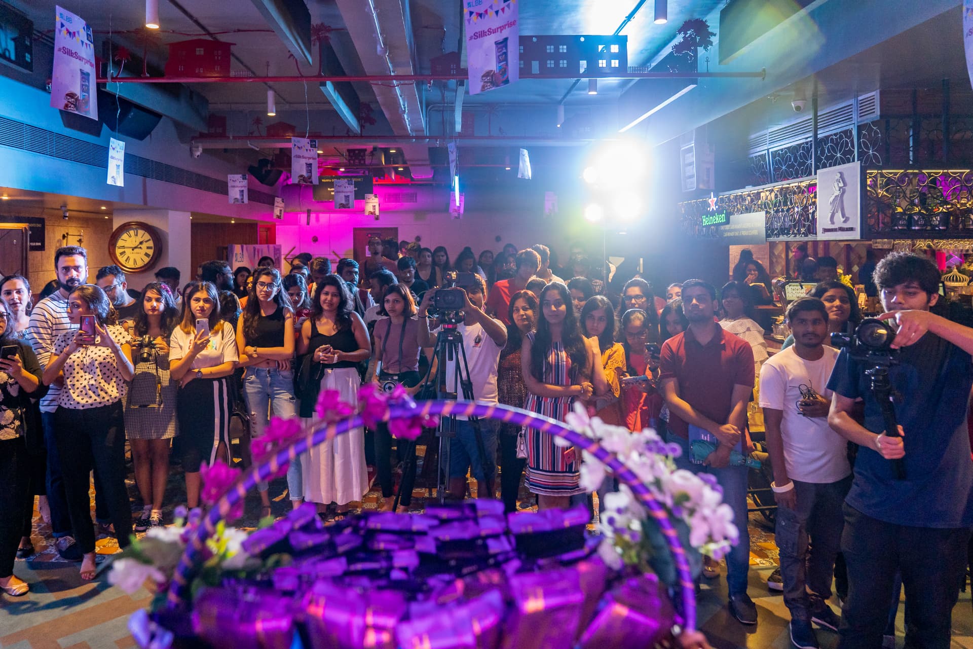 Crowd watching the event under hanging #SilkSurprise banners.